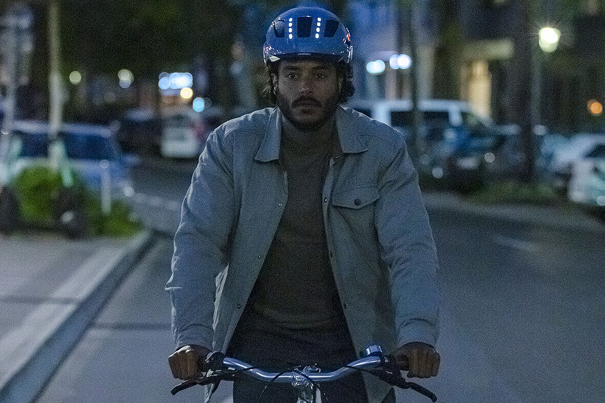 Mann auf Fahrrad mit beleuchtetem Helm